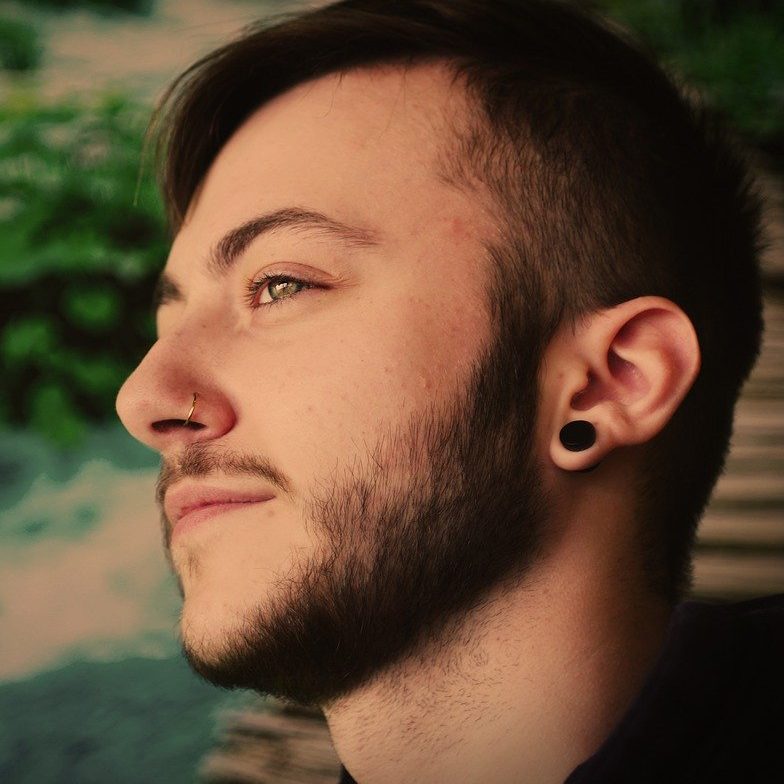 Photo of a man with a nose piercing and ear piercing